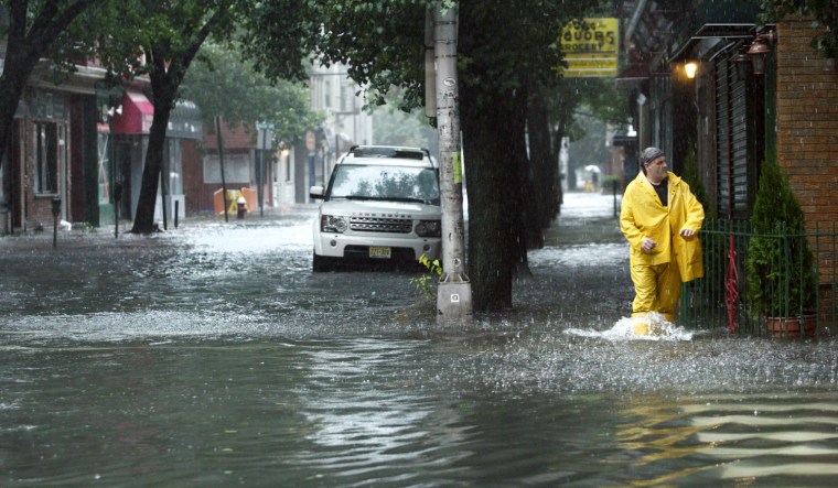 Image: A man walks in a flooded street in Hoboken in New Jersey