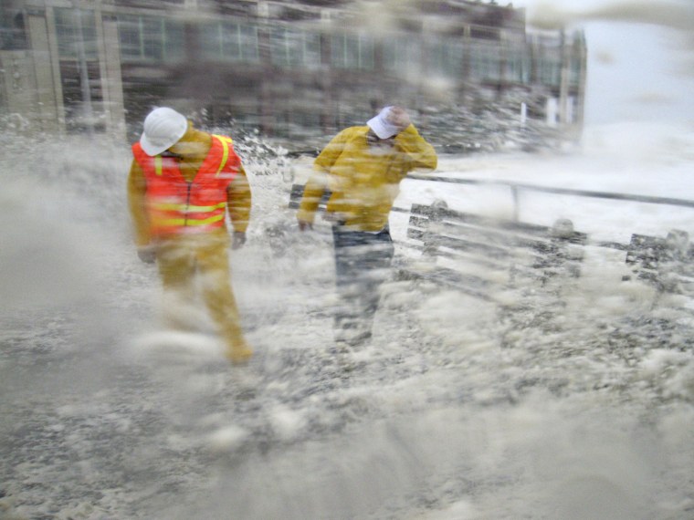 Image: Brian Grant and Bob Bianchini, engineers from the public works department out for a safety inspection, are slammed by waves and storm surge pounding the boardwalk and the beach at first light as Hurricane Irene slams into Asbury Park