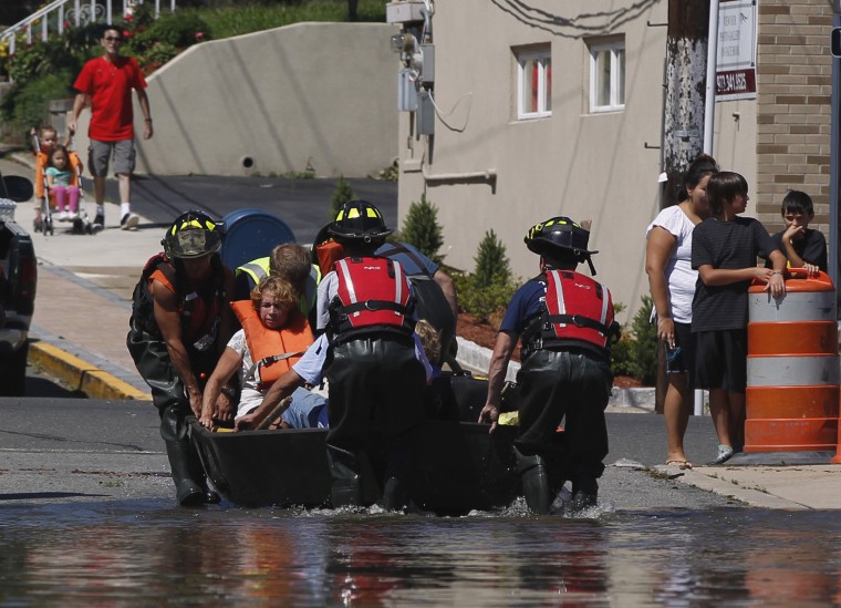 Image: Volunteer fire fighters help to evacuate people from their flooded homes in Totowa, New Jersey