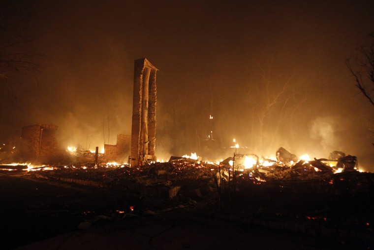 Image: The chimney of a house remains standing as the rest of the building burns to the ground near Bastrop