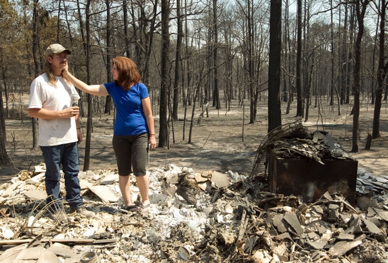 Deborah Torkelson consoles her husband Nathan Torkelson as they stand on what's left of their destroyed home on Cardinal Loop in Bastrop's Circle D Estates neighborhood on Tuesday Sept. 6, 2011. The massive wildfire in Bastrop County has now burned 34,800 acres, destroyed 577 home and forced 20 neighborhoods to evacuate, officials said.
