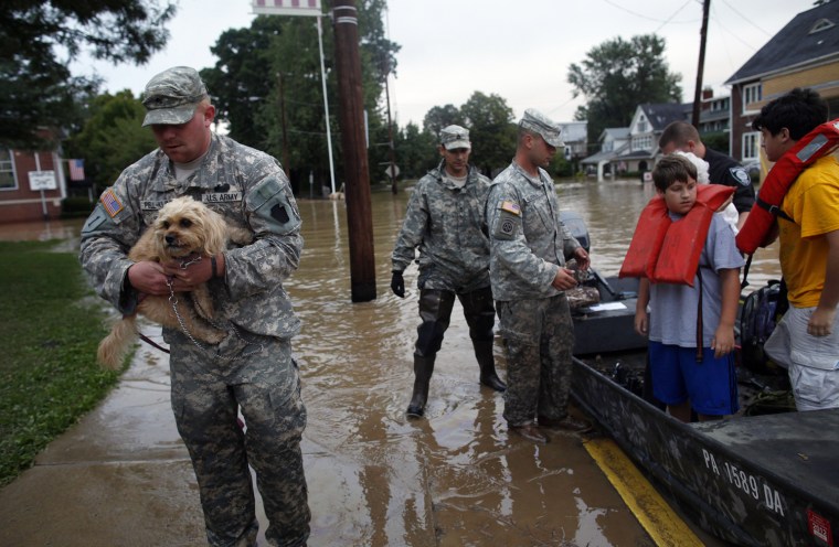 Image: A U.S. National Guard troop carries a dog named Charlie as residents are rescued from floodwaters from the Susquehanna River in West Pittston