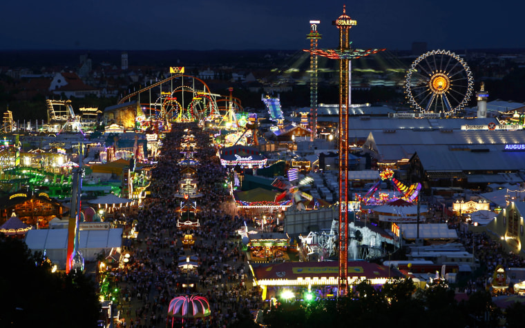 Image: Tens of thousands of revellers stroll at the Munich Oktoberfest, at the Theresienwiese in Munich