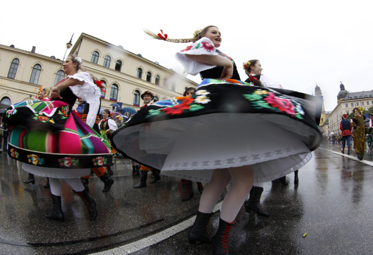 Image: People in traditional costumes dance during Oktoberfest parade in Munich