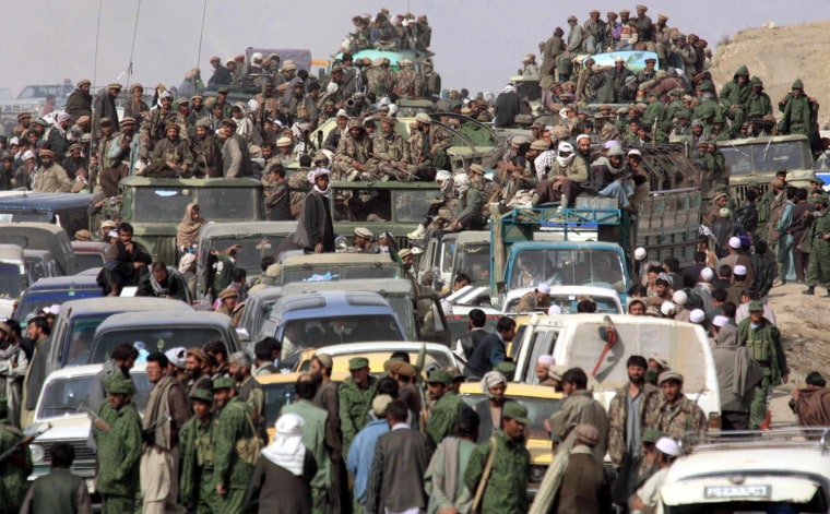 Thousands of refugees from Kabul and troops wait for the permission to enter the Northern outskirts of Kabul 13 November 2001, after Northern Alliance soldiers captured the capital. Opposition forces poured into Kabul on Tuesday chasing the Taliban militia from the capital, as the hardline regime which dragged the country back into the Middle Ages for five years appeared to be on the run. AFP PHOTO/Alexander NEMENOV