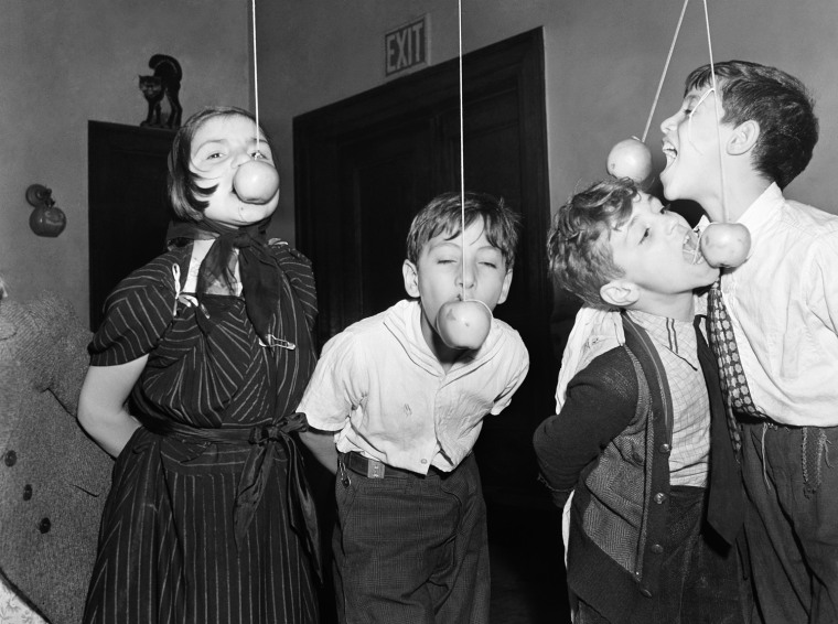 One of the games played at every Halloween party is eating, or rather, trying to eat apple suspended on a string with your hand behind you.  They were few of the children of New York's Little  Italy who were guests at the Annual Halloween Party sponsored by the Children's Aid Society in New York, Oct. 25, 1939. (AP Photo)