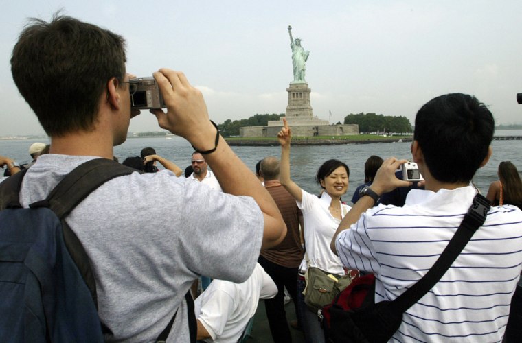 Image: Tourists photograph the Statue of Libert
