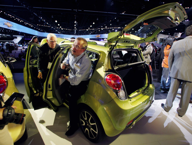 Image: Two men step out of the 2013 Chevrolet Spark after it was unveiled at the LA Auto Show in Los Angeles
