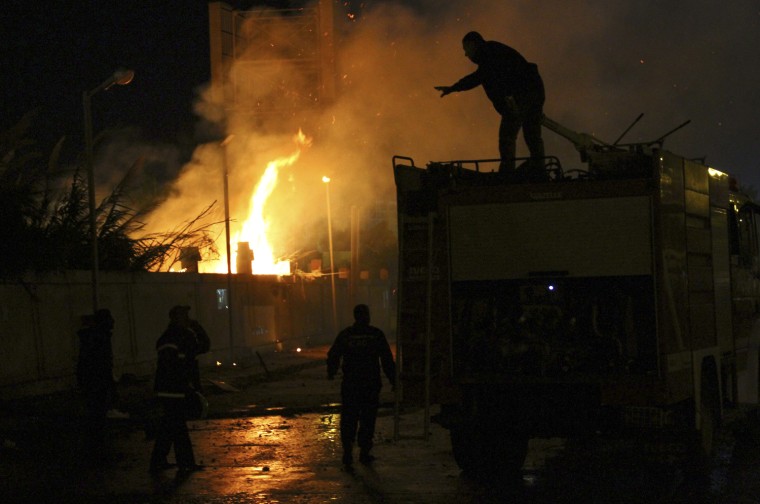 Image: Firemen fire try to put out a fire started by protesters during clashes with police in Alexandria