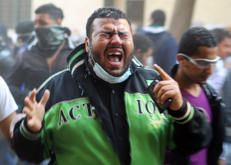 Image: A protester cries due to the pain in his eyes caused by tear gas during clashes near Tahrir Square in Cairo
