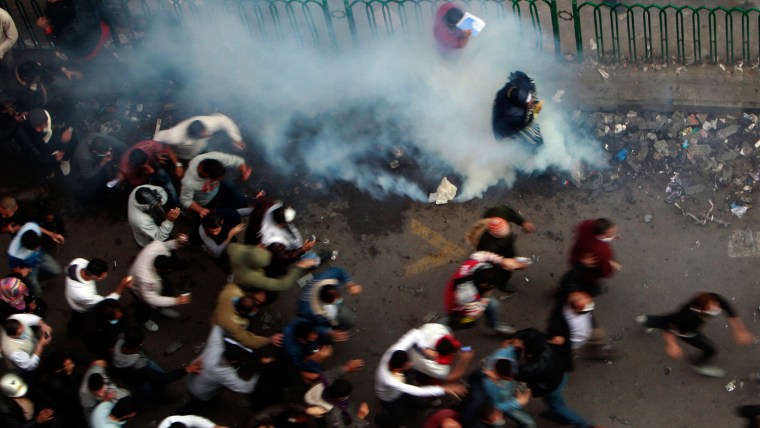 Image: Protesters run from tear gas fired by riot police during clashes at Tahrir Square in Cairo