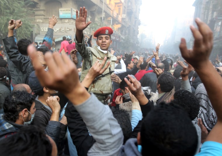 An Egyptian soldier tries to keep thousands of protesters away from riot policemen during a demonstration in Cairo's landmark Tahrir Square on the fourth day of clashes with security forces on November 22, 2011, to demand an end to military rule, heightening tension after days of deadly clashes that threaten to derail next week's legislative polls.  AFP PHOTO/KHALED DESOUKI (Photo credit should read KHALED DESOUKI/AFP/Getty Images)