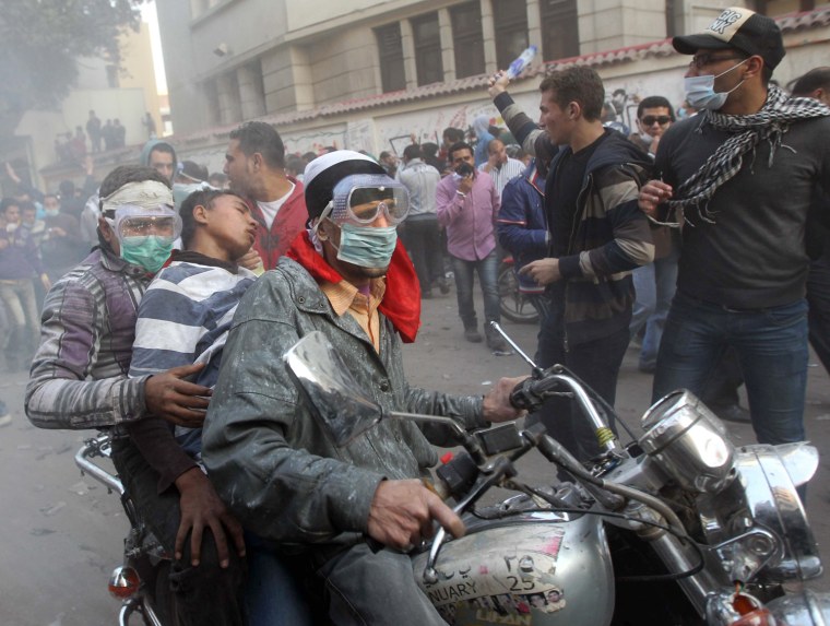 Protesters transfer a wounded comrade to a nearby hospital on a motorbike during a demonstration by tens of thousands of Egyptians in Cairo's landmark Tahrir Square on November 22, 2011,  as clashes between police and protesters demanding democratic change entered a fourth day.   AFP PHOTO/KHALED DESOUKI (Photo credit should read KHALED DESOUKI/AFP/Getty Images)