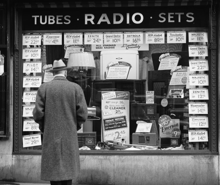 1940s MAN LOOKING AT WINDOW DISPLAY OF RADIOS ON SALE IN NEW YORK CITY. C.P. CUSHING/CLASSICSTOCK/Everett Collection (q40385)