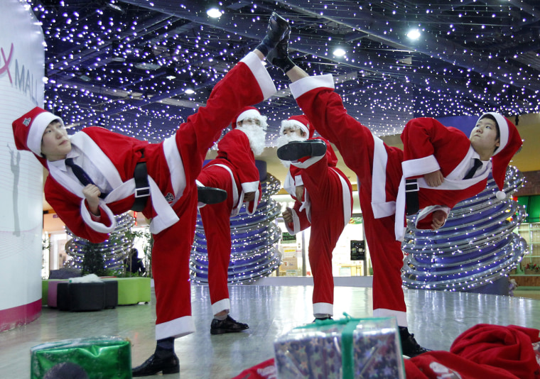 Image: Security guards in Santa Claus costumes perform martial arts during a promotional event at a mall in Seoul