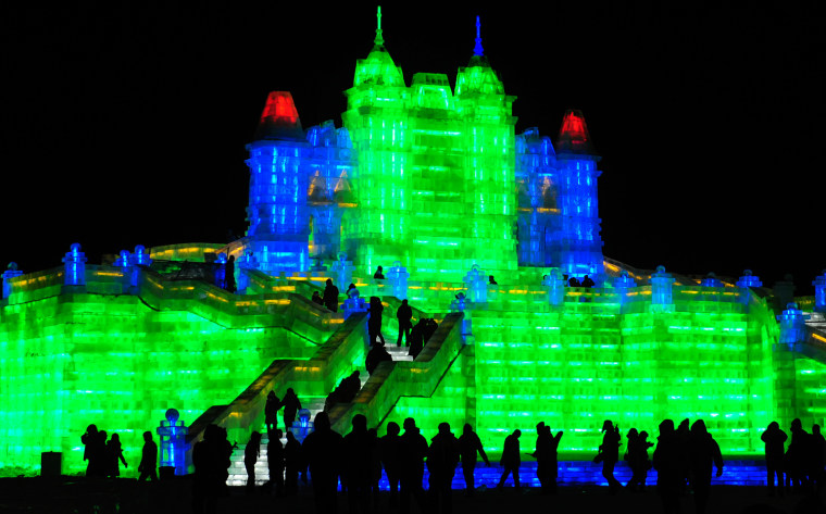 Image: Tourists visit ice sculptures during the the lights testing period of the 13th Harbin Ice and Snow World in Harbin