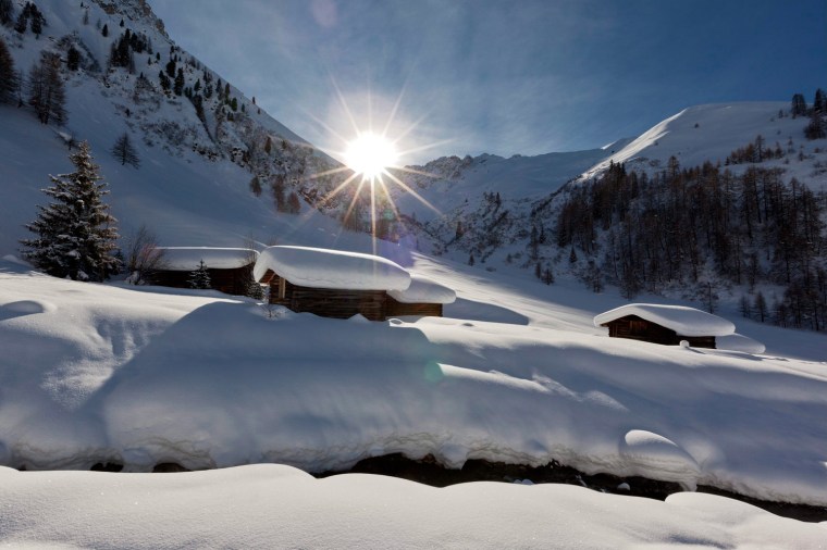 Image: The sun shines on snowed up stables in Sapuen near Langwies in the Swiss canton of Grisons