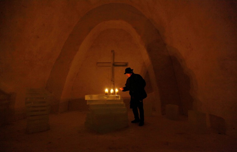 Image: A Catholic priest looks at the ice altar inside a church made of snow in the Bavarian village of Mitterfirmiansreut