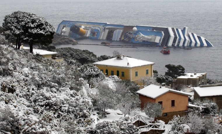 Image: The capsized Costa Concordia cruise ship is seen off the west coast of Italy at the snow-covered Giglio island