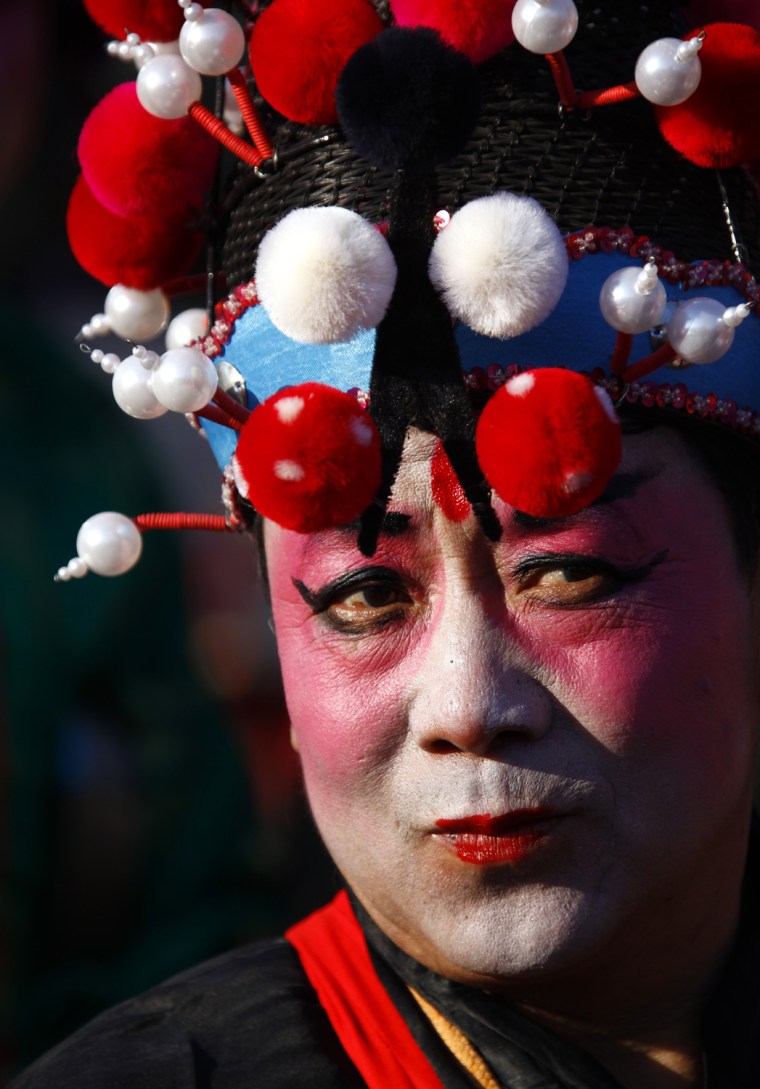 Image: Performer dressed in traditional costume and wearing make-up prepares to take part in Chinese new year celebrations at Dongyue Temple in Beijing