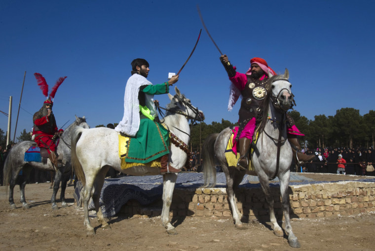 Image: Actors take part in a re-enactment of the 7th century battle of Kerbala during the \"Taziyeh\" religious theatre performance on Tasoua, a day before Ashura, in Noushabad