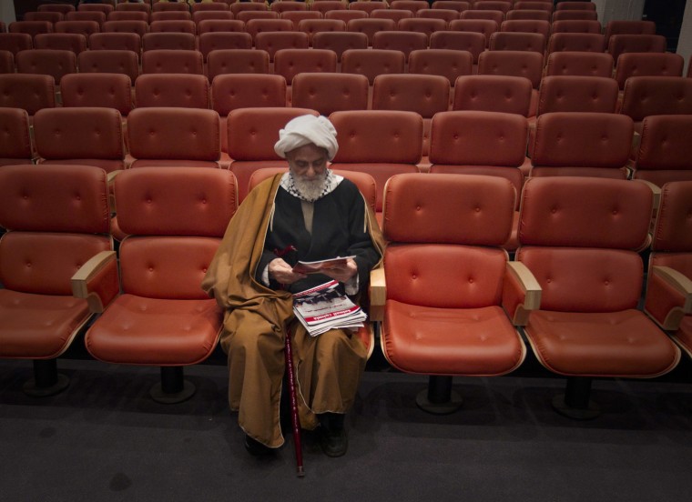 Image: A cleric waits for the start of a conference titled \"Gaza, a Symbol of Resistance\" in Tehran