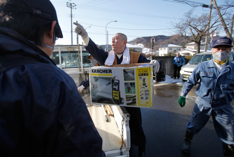 Image: Koyu Abe, a Zen priest, gives instructions to volunteers during a radiation cleansing event hosted by himself in Fukushima
