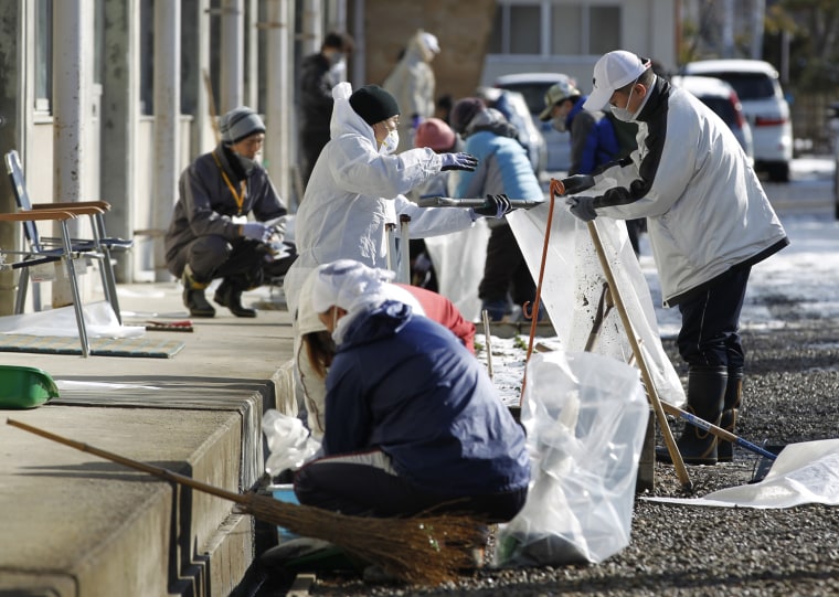 Image: Volunteer workers clean inside ditches during a radiation cleansing event hosted by Zen priest Koyu Abe in Fukushima