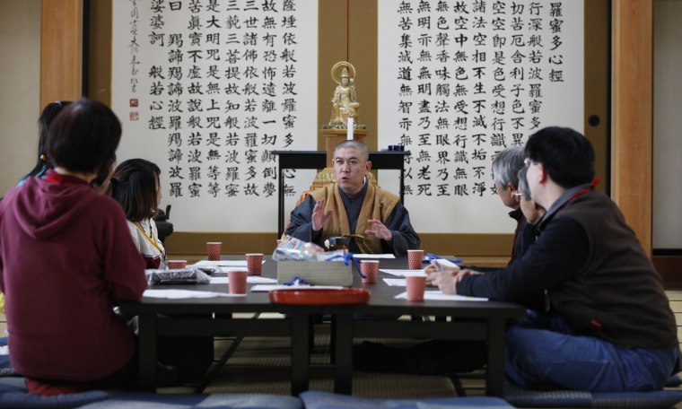 Image: Koyu Abe, a Zen priest, talks to volunteers before a workshop to inform local residents on how to deal with radioactive contamination at Joenji temple in Fukushima