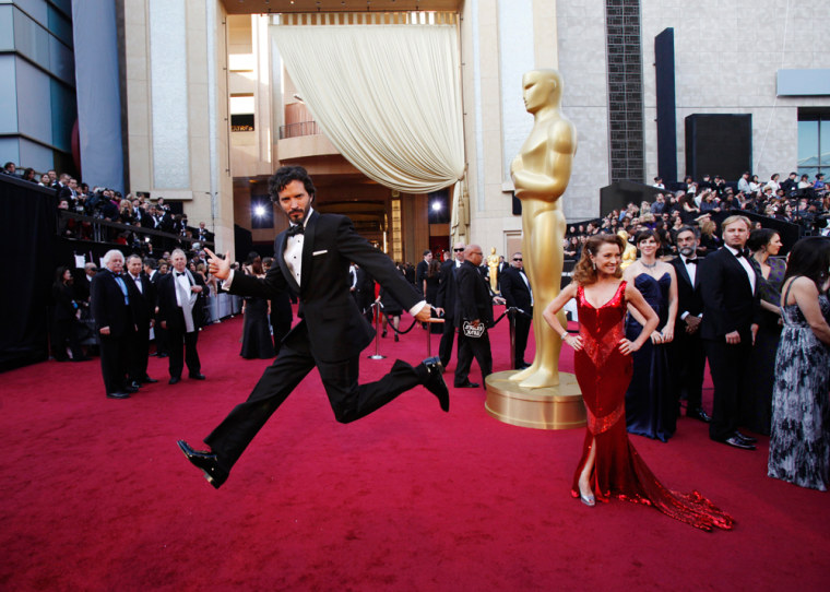 Image: Bret McKenzie, nominated for the original song award, jumps near actress Jane Seymour posing at the 84th Academy Awards in Hollywood