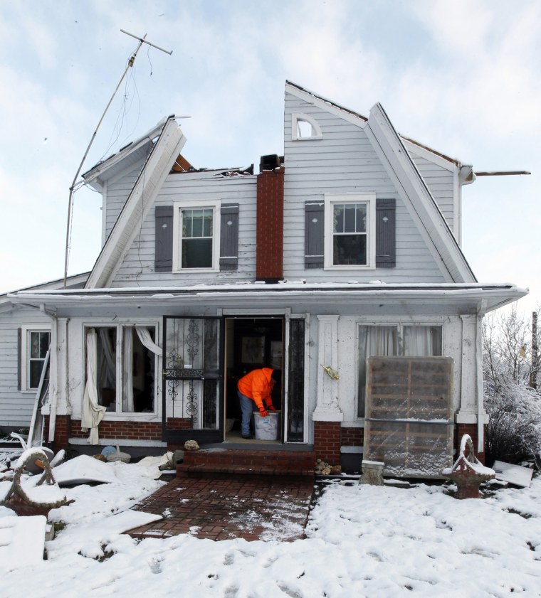 Image: Snow covers a storm-damaged house in Henryville