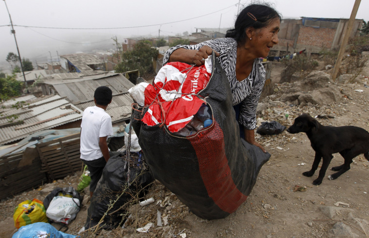 Image: A woman carries a bag containing plastic bottles before selling the bottles in Ticlio Chico in Villa Maria del Triunfo on the outskirts of Lima