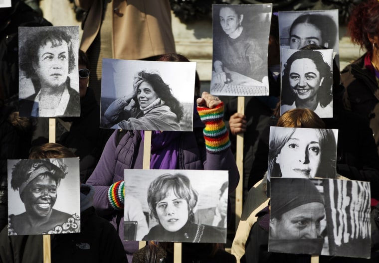 Image: Women hold pictures of famous female activists during demonstrations to mark International Women's Day in Belgrade