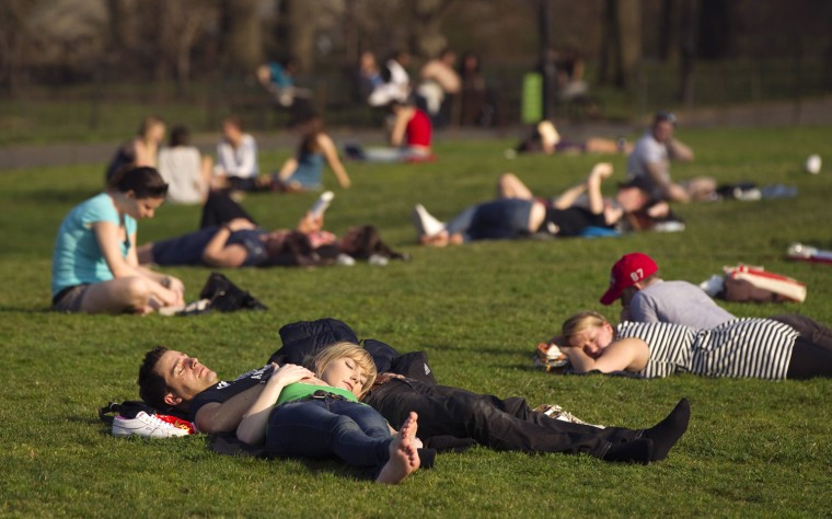 Image: A couple relaxes on the grass at Central Park during a warm day in New York