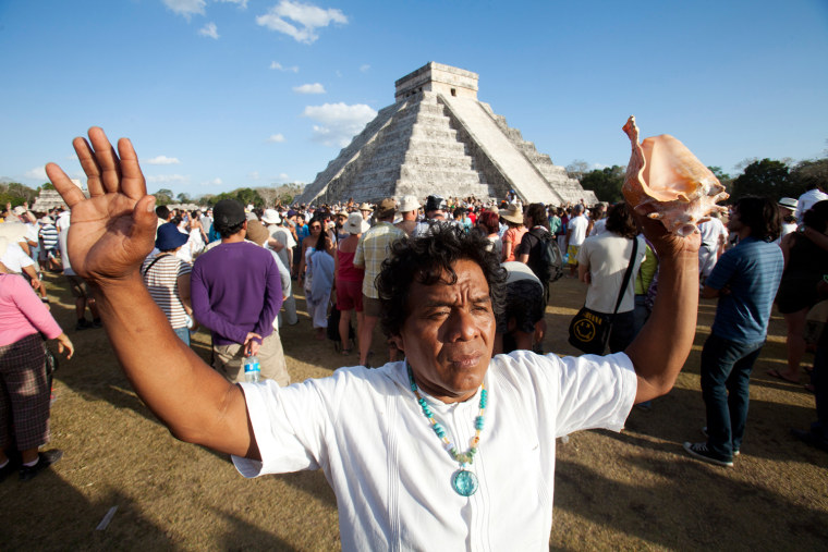 Image: A man raise his hands near the pyramid of Chichen Itza in the southern Mexican state of Yucatan