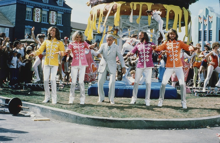 British pop group the Bee Gees take part in a scene during the filming of 'Sgt. Pepper's Lonely Hear Club Band' in California, April 1978. From left to right; Robin Gibb; Peter Frampton, British singer; George Burns, American comic and actor; Maurice Gibb; Barry Gibb. (AP Photo)