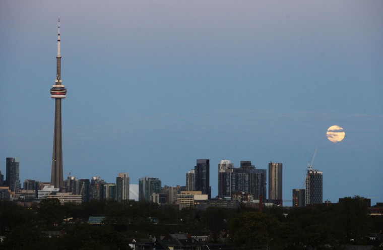 Image: The \"super Moon\" rises over the skyline in Toronto