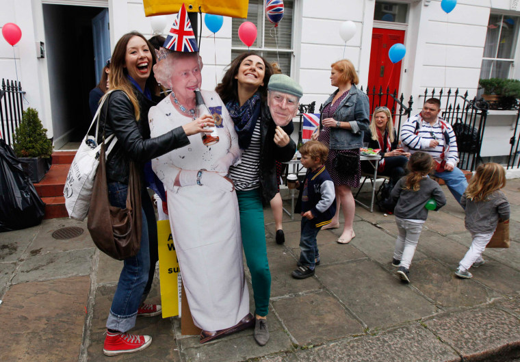 Image: People pose with a cutout of Britain's Queen Elizabeth during a street party to celebrate her Diamond Jubilee at Primrose Hill in London