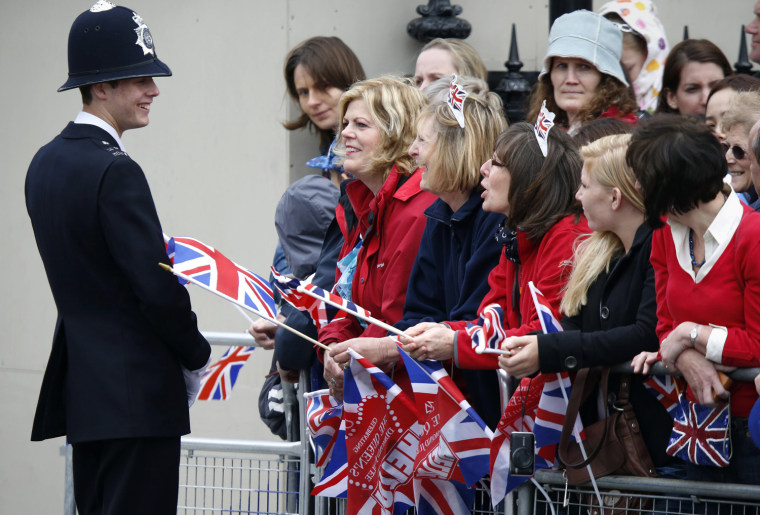 Image: Spectators speak to a policeman as they stand in Parliament Square to see the Queen in London
