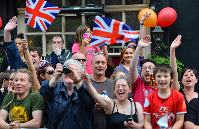 Image: Crowds cheer as the Olympic Torch passes