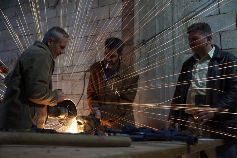 Image: Members of the Free Syrian Army work on an improvised mortar shell in Deir al-Zor