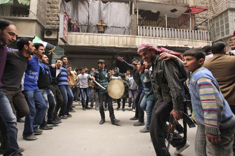 Image: Demonstrators chant slogans and dance during a protest against Syria's President Bashar al-Assad in Aleppo