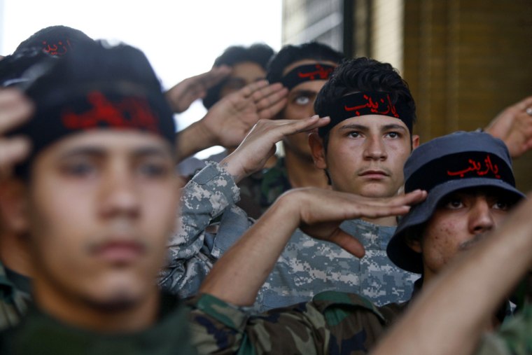 Image: Iraqi Shi'ite fighters salute at Sayeda Zainab area in Damascus