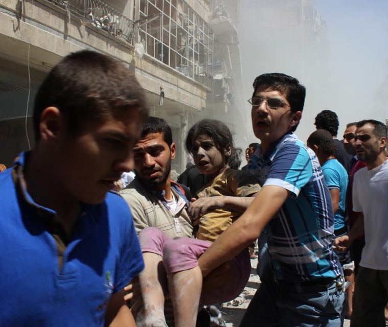 Image: Men carry a wounded girl rescued from under rubble after what activists said was shelling by forces loyal to Syria's President Bashar Assad in Aleppo