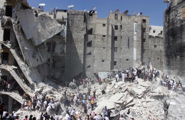 Image: People gather as they search for survivors under the rubble of collapsed buildings after what activists said was shelling by forces loyal to Syria's President Assad in Aleppo