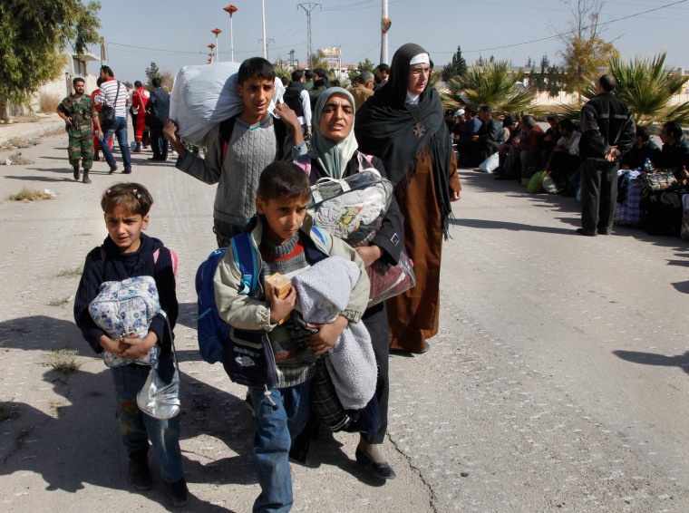 Image: Syrian families leave besieged town of al-Moadamiyeh, which is controlled by opposition fighters, in Damascus