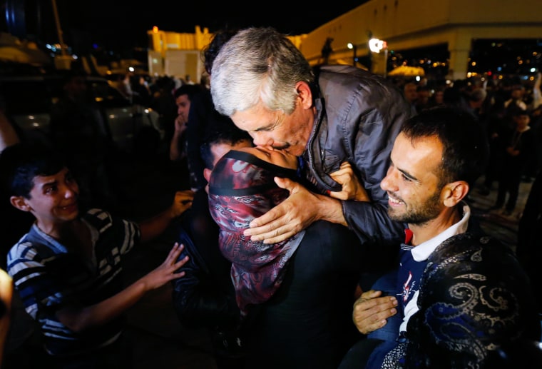 Image: One of the nine newly released Lebanese hostages, who were held by rebels in northern Syria, kisses his wife upon his arrival at Beirut international airport