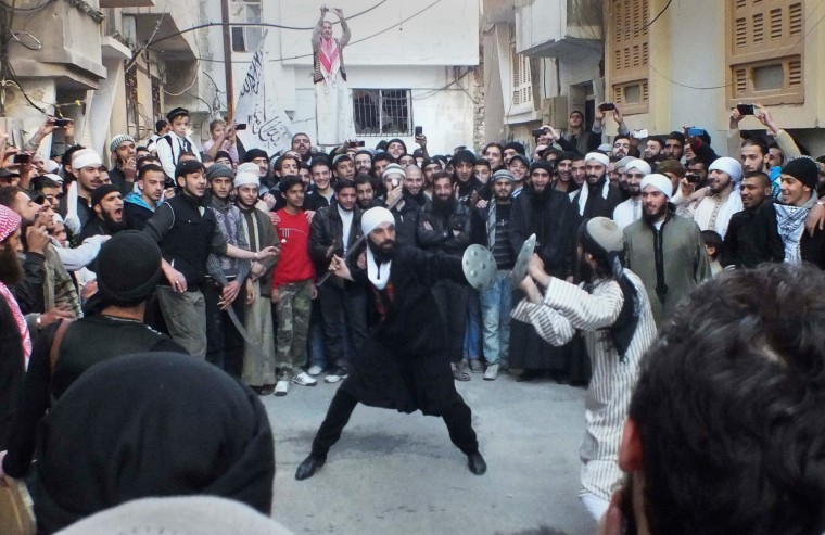 Image: Men perform a folk sword dance as people watch on the first day of Eid al-Adha in Homs
