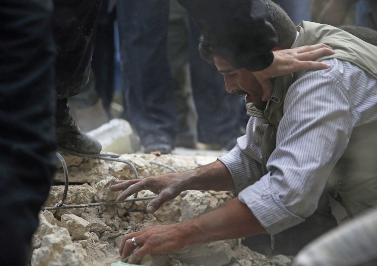 Image: A father reacts while trying to search for his daughters under the rubble at a site hit by what activists say was an air strike by forces loyal to Syrian President Bashar al-Assad in the Duma neighbourhood of Damascus
