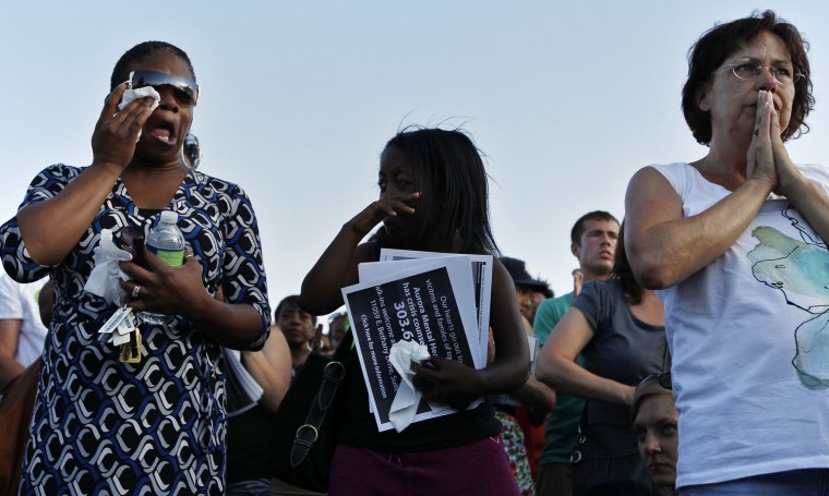 Image: People pray during a vigil for victims behind the theater where a gunman opened fire in Aurora, Colorado